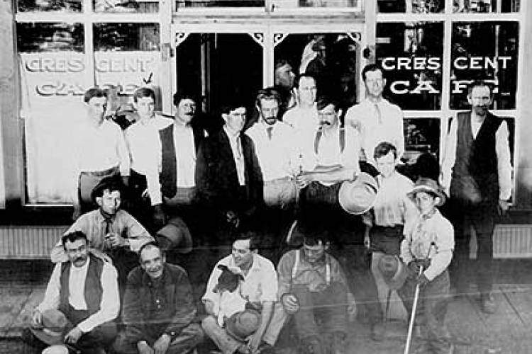 a black and white photo of male residents of Courtland residents in front of the Courtland Cafe in 1909